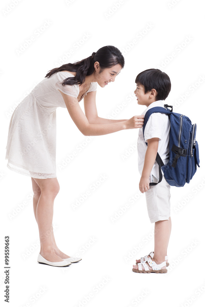 Young mother preparing son for school