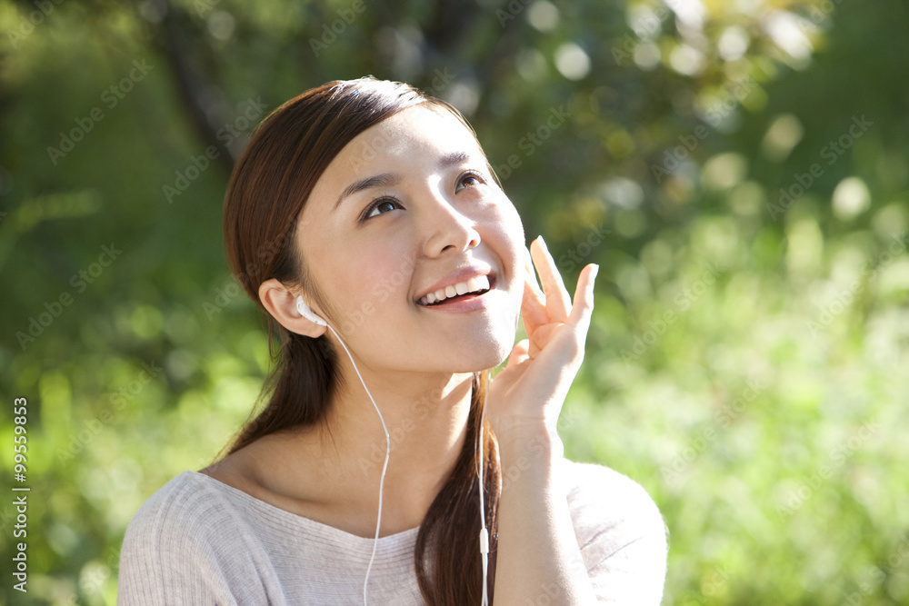 Young woman outdoors listening to music