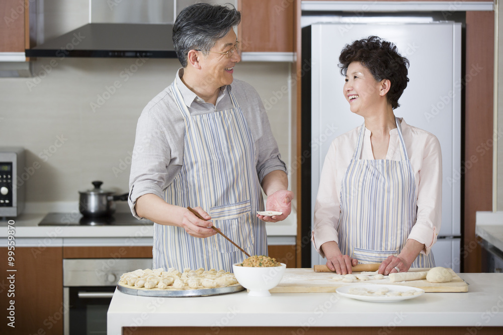 Happy senior couple making dumplings