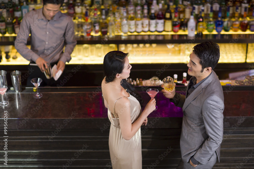 Young man and woman chatting at bar