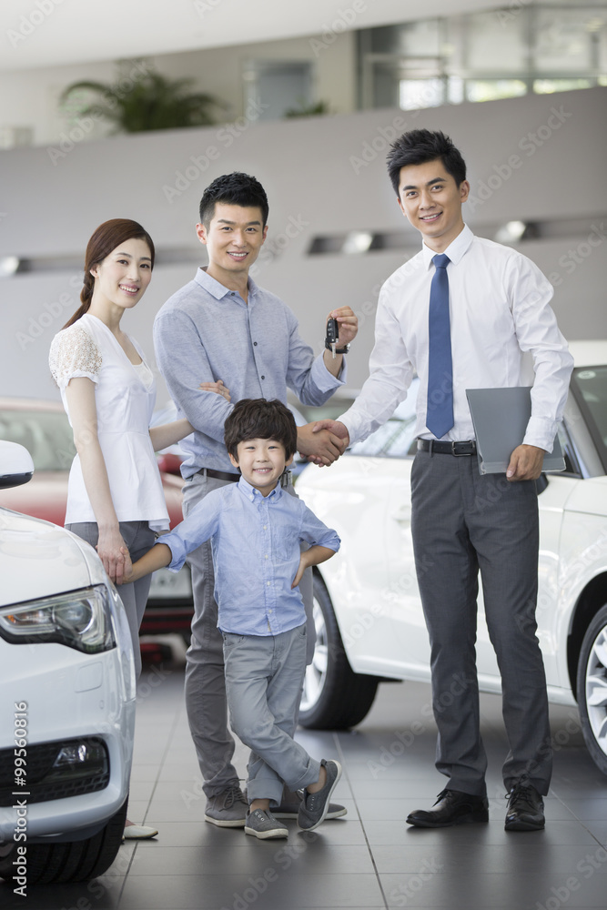 Young family buying car in showroom