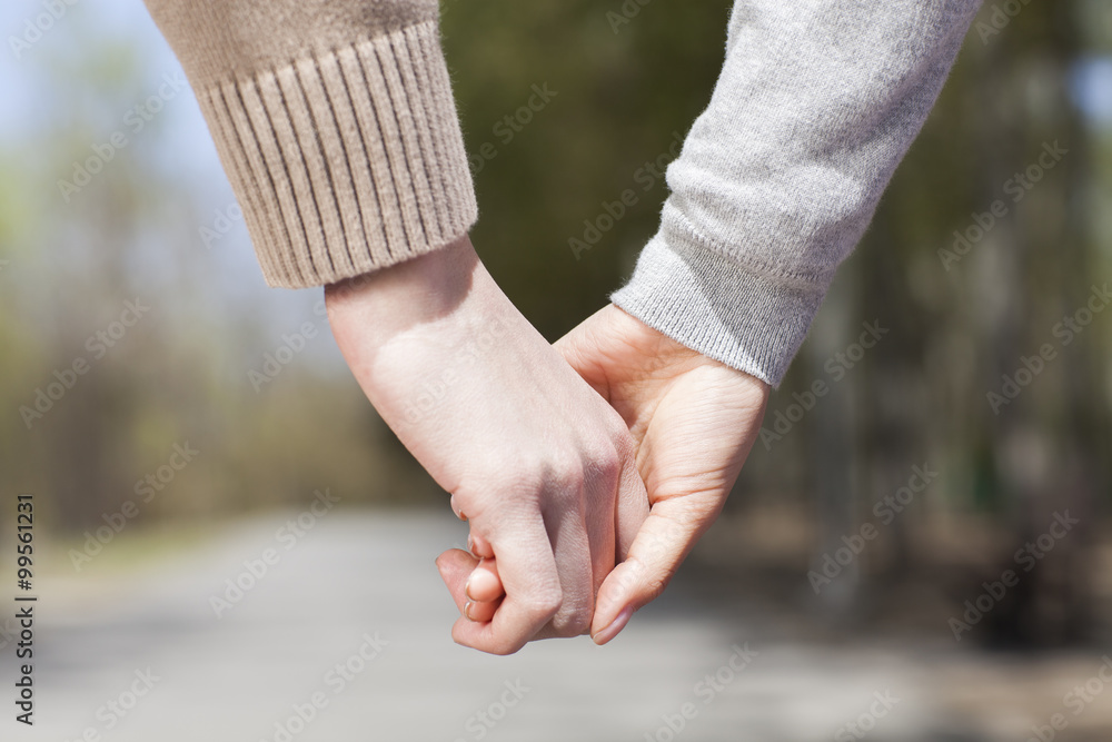 Close up of young couple holding hands