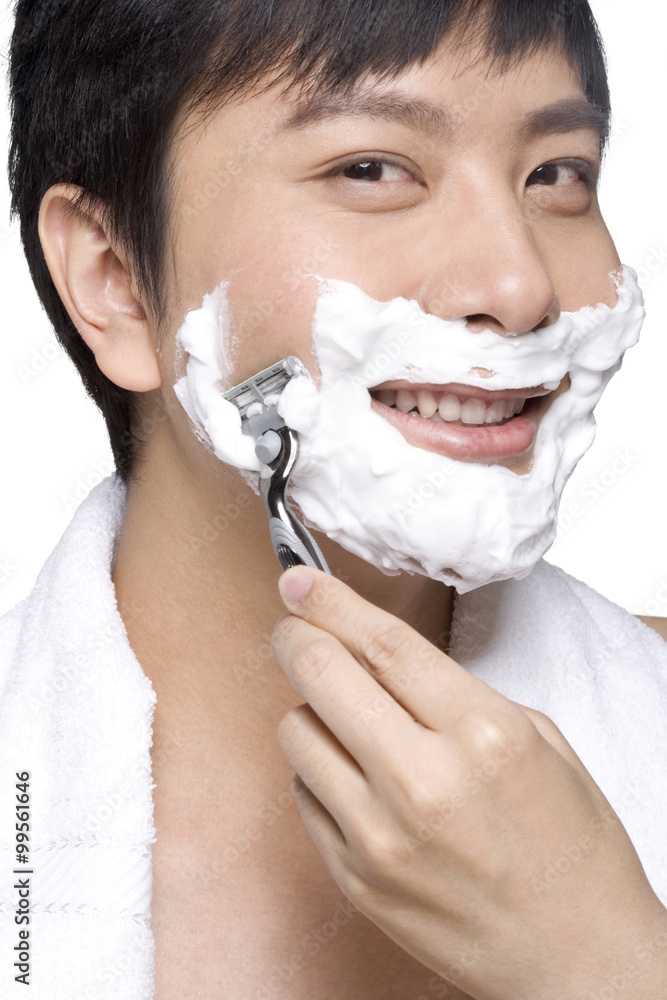 Handsome young man shaving