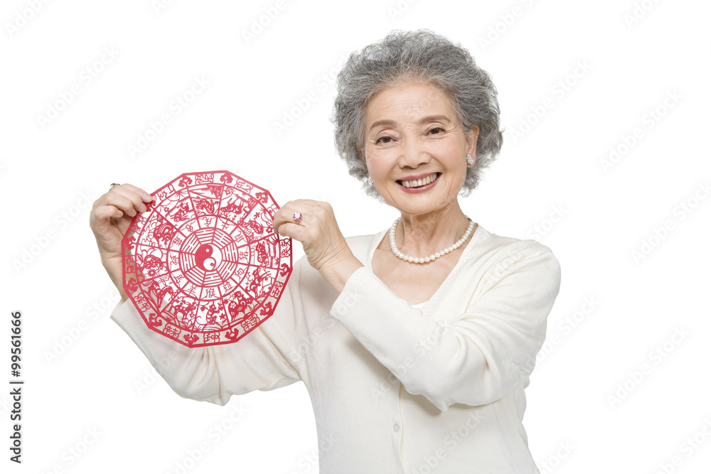 Senior woman holding traditional paper cutting