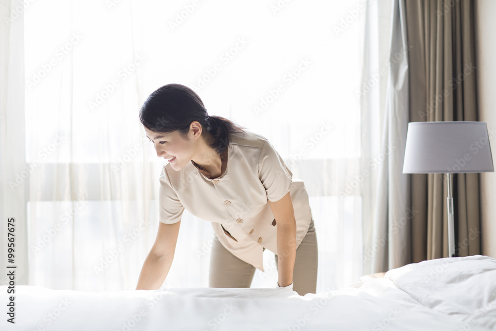 Domestic staff cleaning bedroom