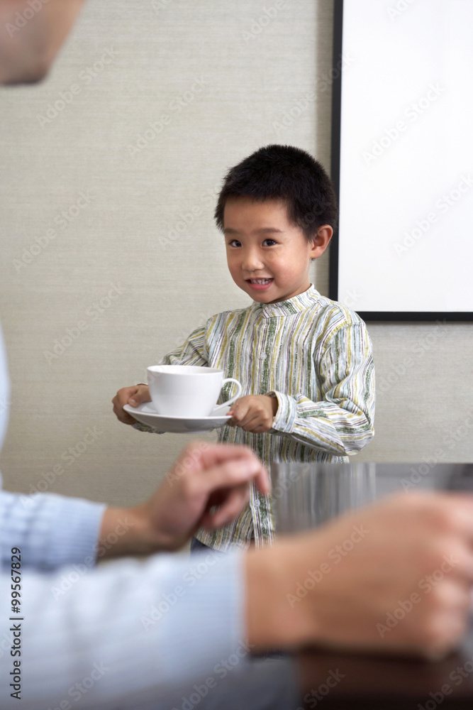 男孩端着一杯茶