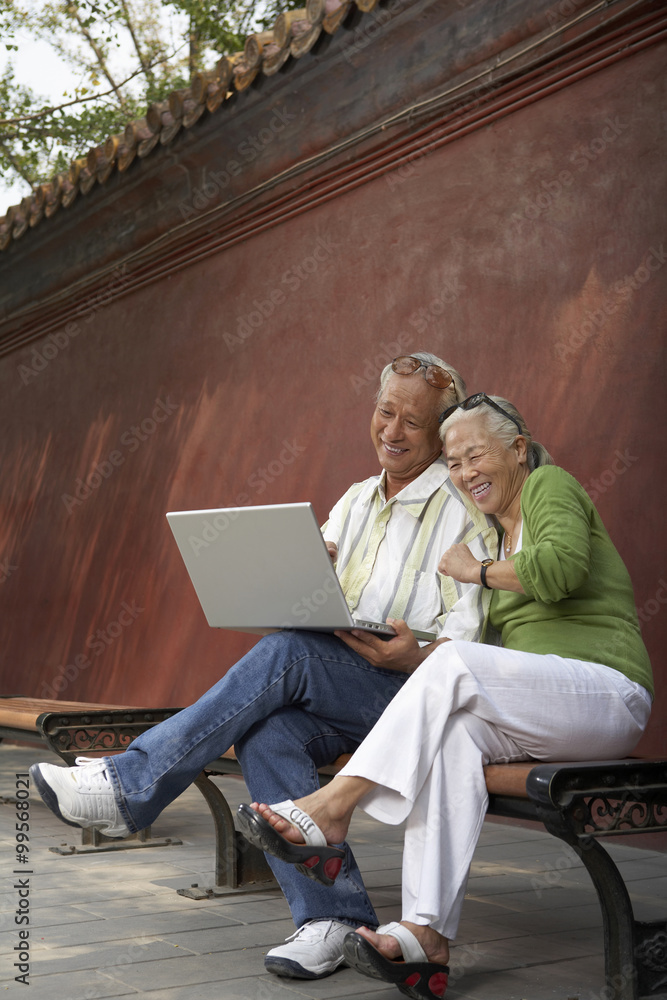 Older Couple Looking At Laptop Computer Together