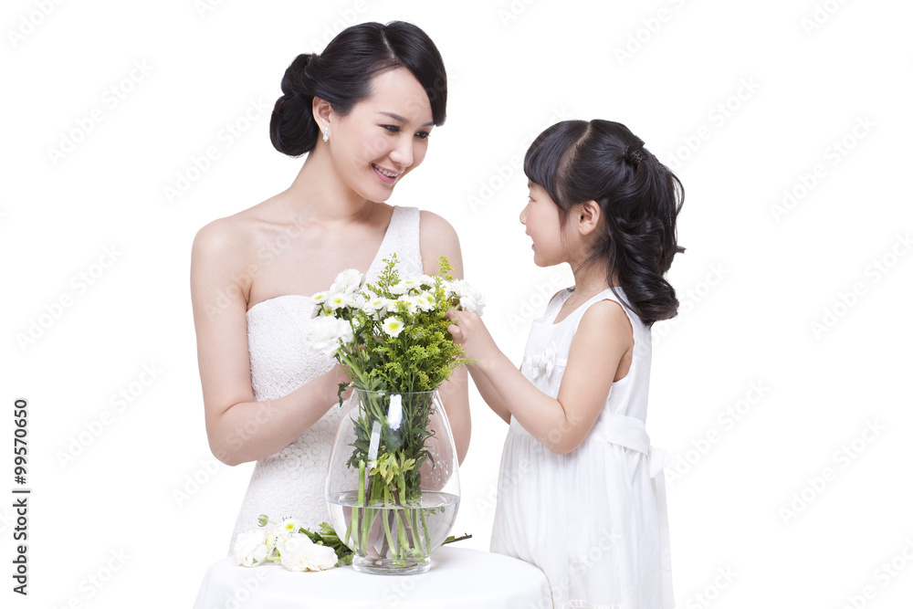 Happy mother and daughter arranging flowers