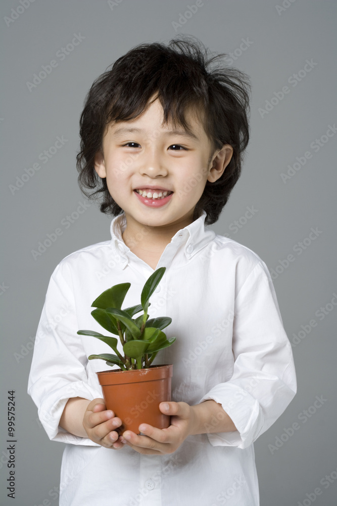 小男孩拿着一株植物