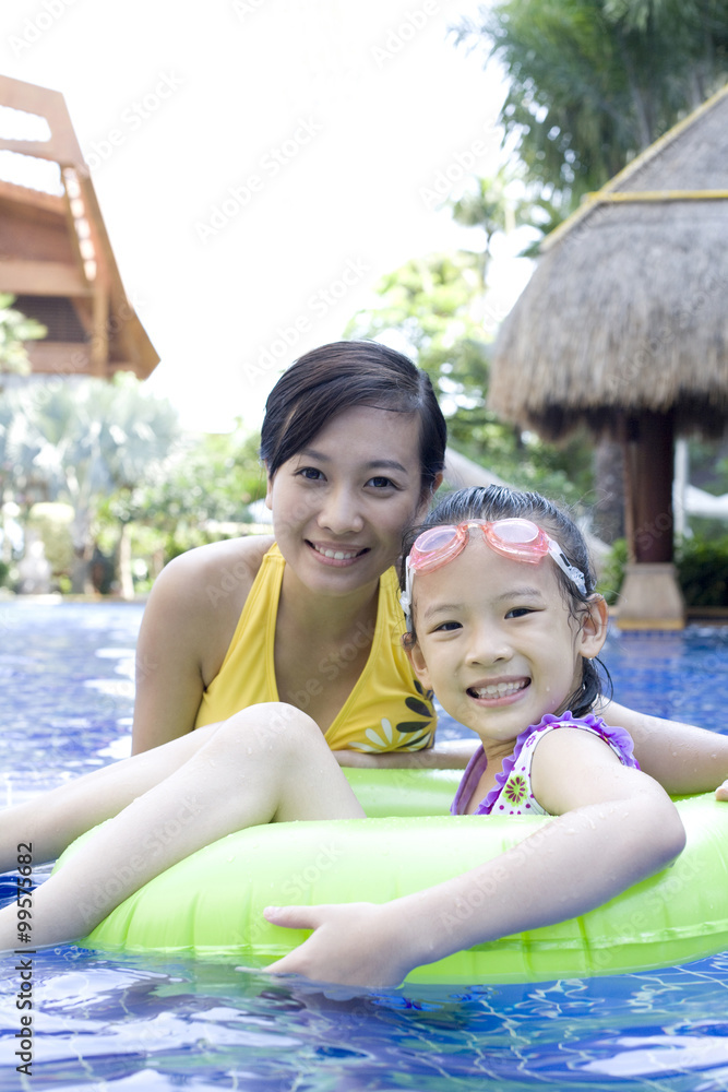 Mother and daughter having fun in the pool