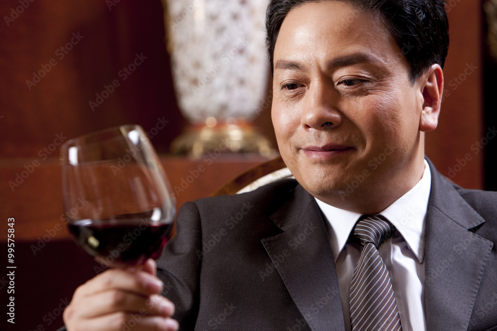 Mature businessman enjoying wine in a luxurious room