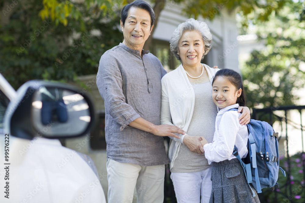 Portrait of little schoolgirl and her grandparents