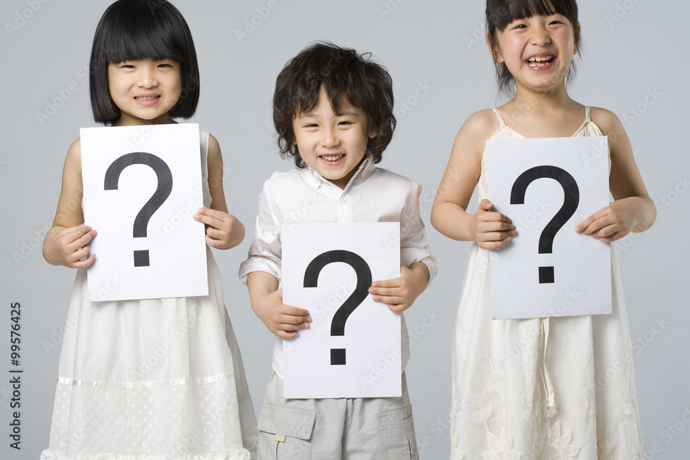 Children holding signs with question marks