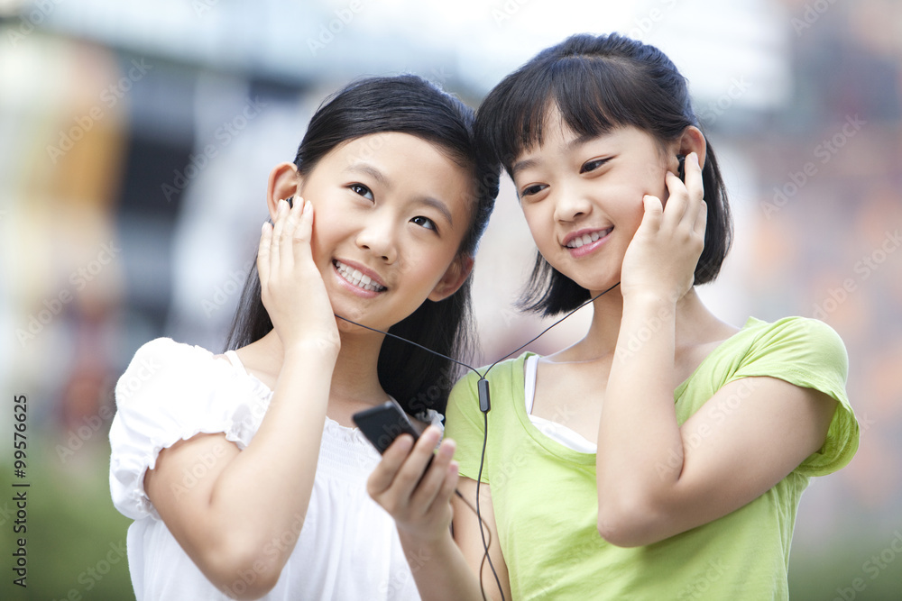 Schoolgirls listening to MP3 player together