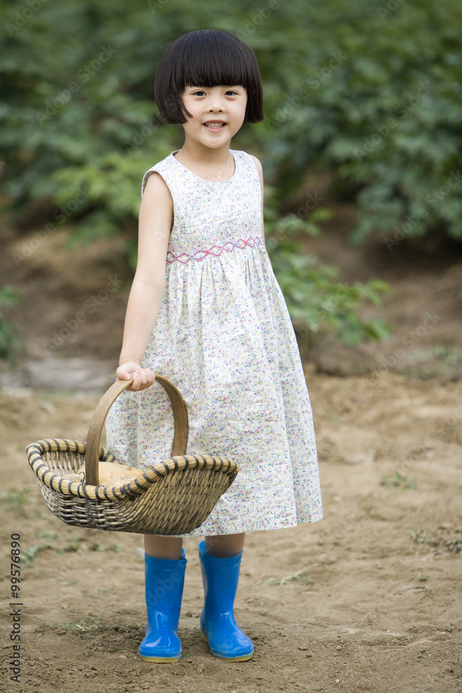 Little girl holding basket in farm