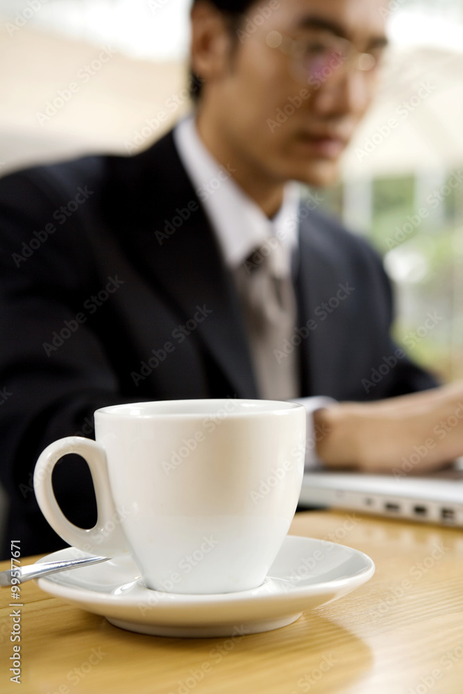 Businessman Using Laptop At Cafe