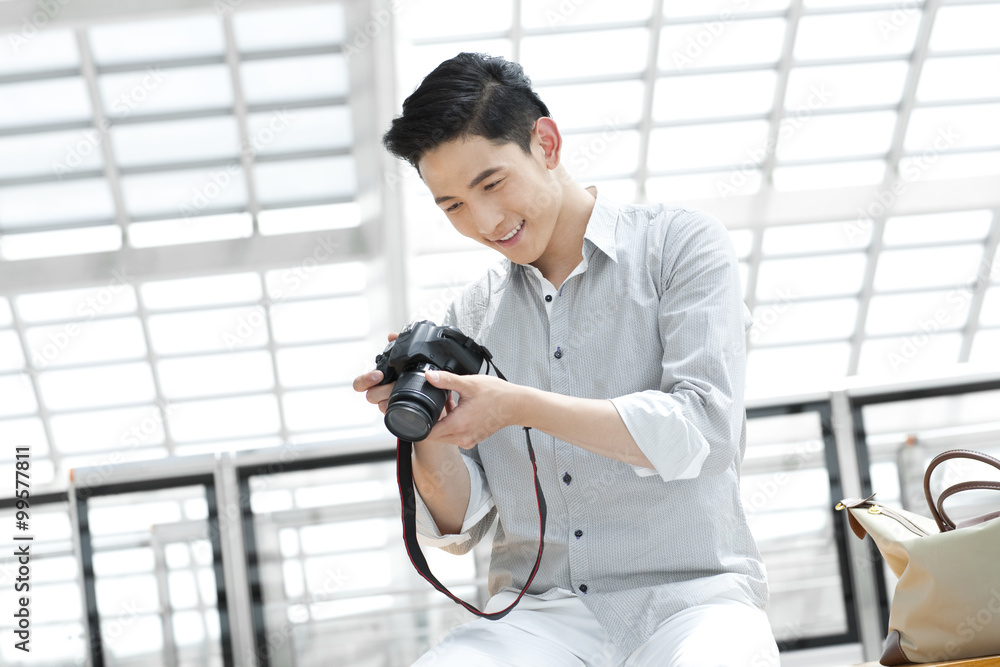 Young man with SLR camera at subway station