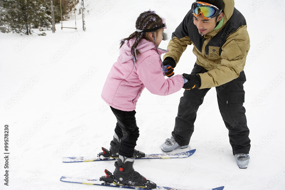 Father Helping Daughter To Ski