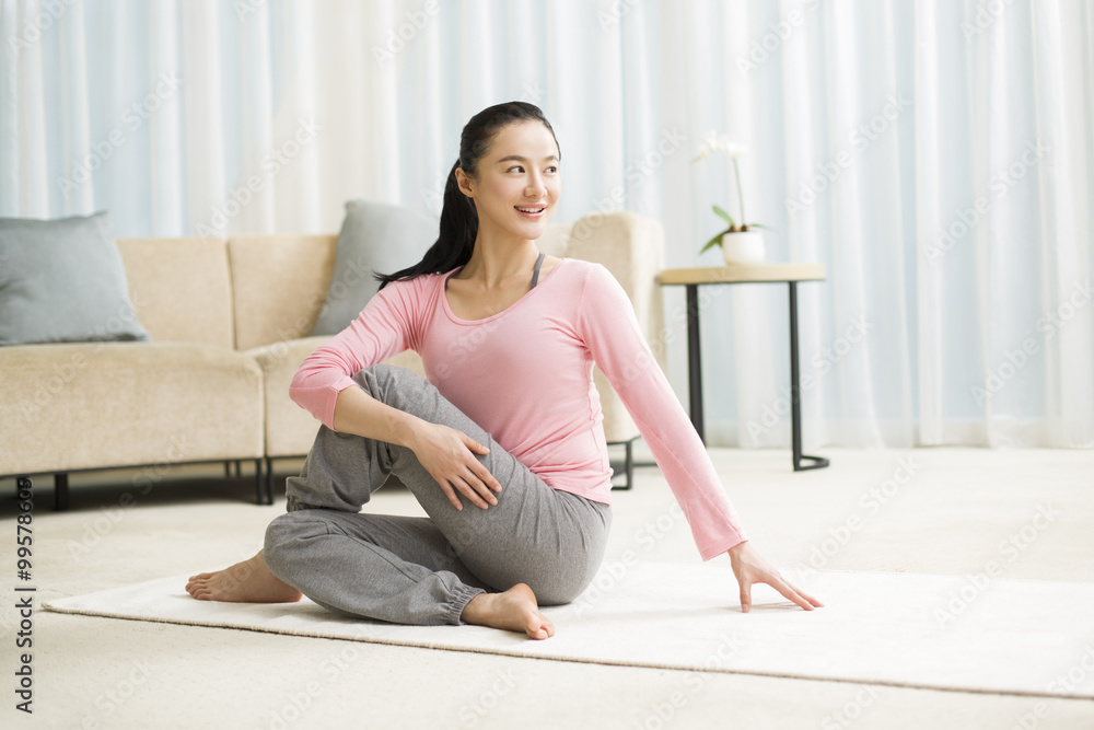 Young woman practicing yoga in living room