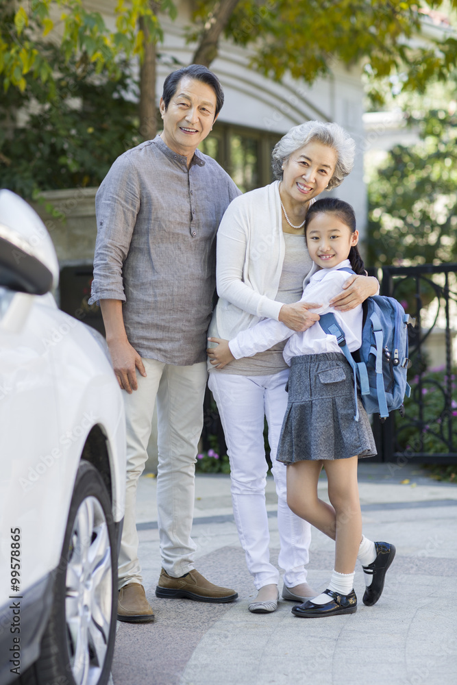 Portrait of little schoolgirl and her grandparents