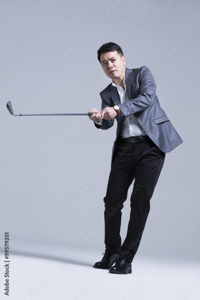 Mature businessman playing golf