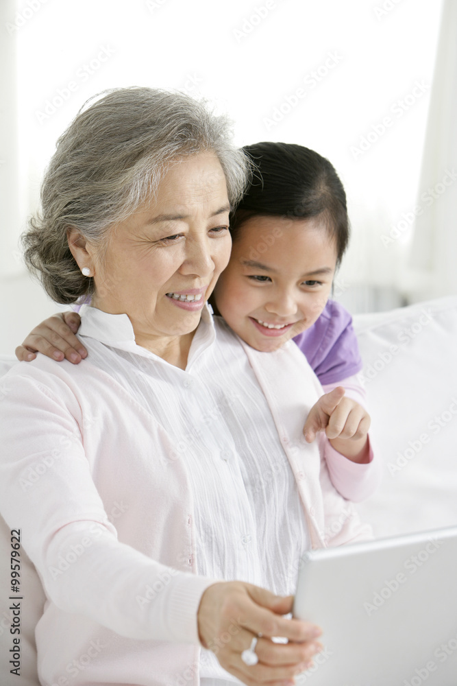 Chinese grandmother with grandaughter using a laptop