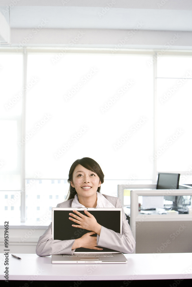 Office worker hugging her computer