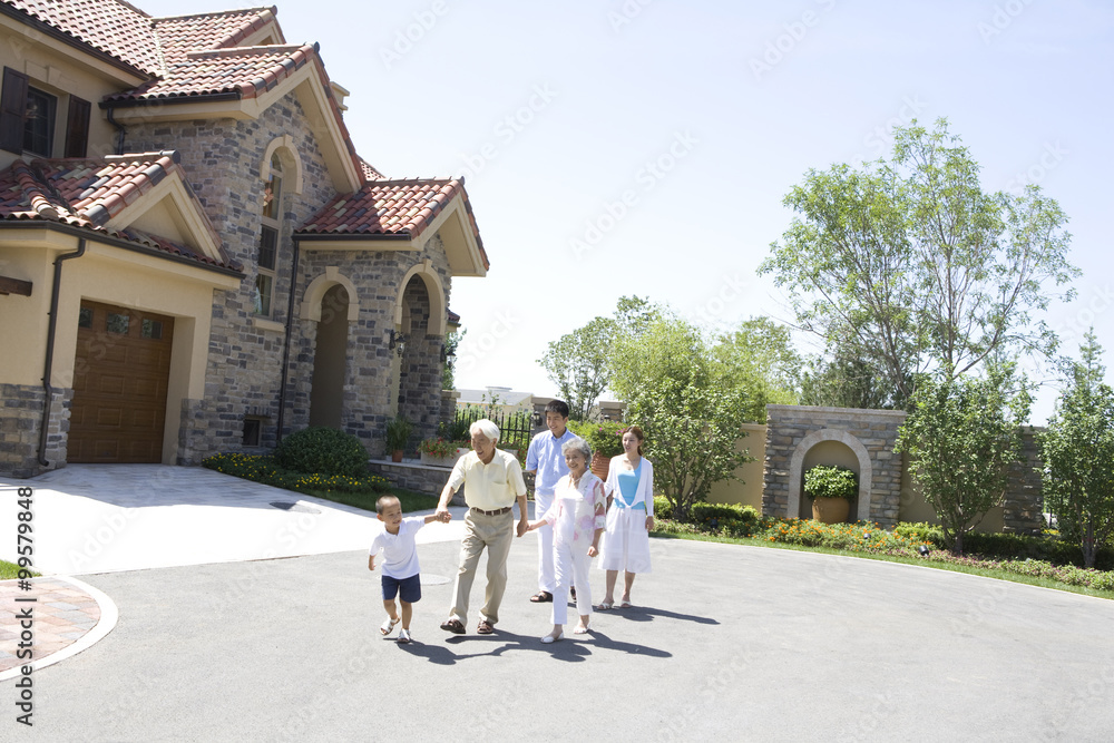 Three generation family walking by a house