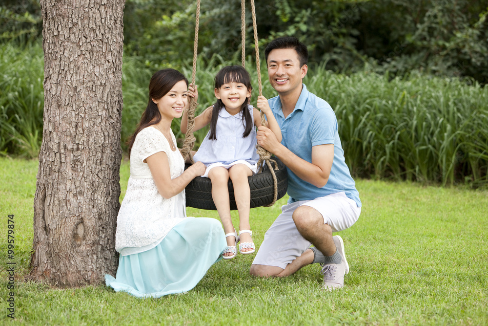 Happy family playing on a swing outdoors