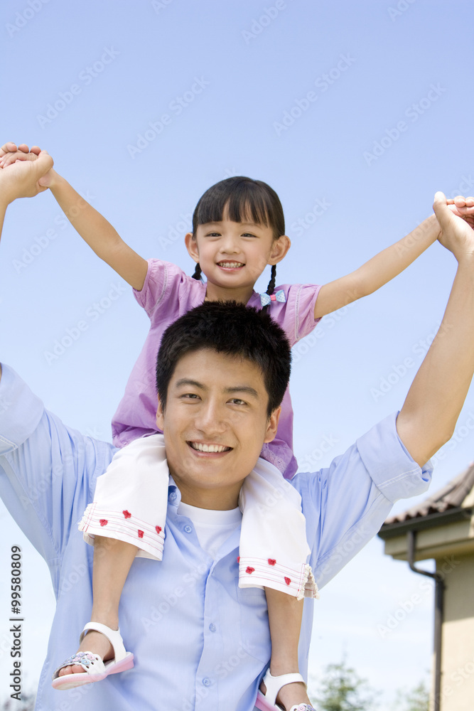 Father carrying daughter on shoulder