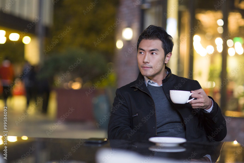 Young man drinking coffee in café