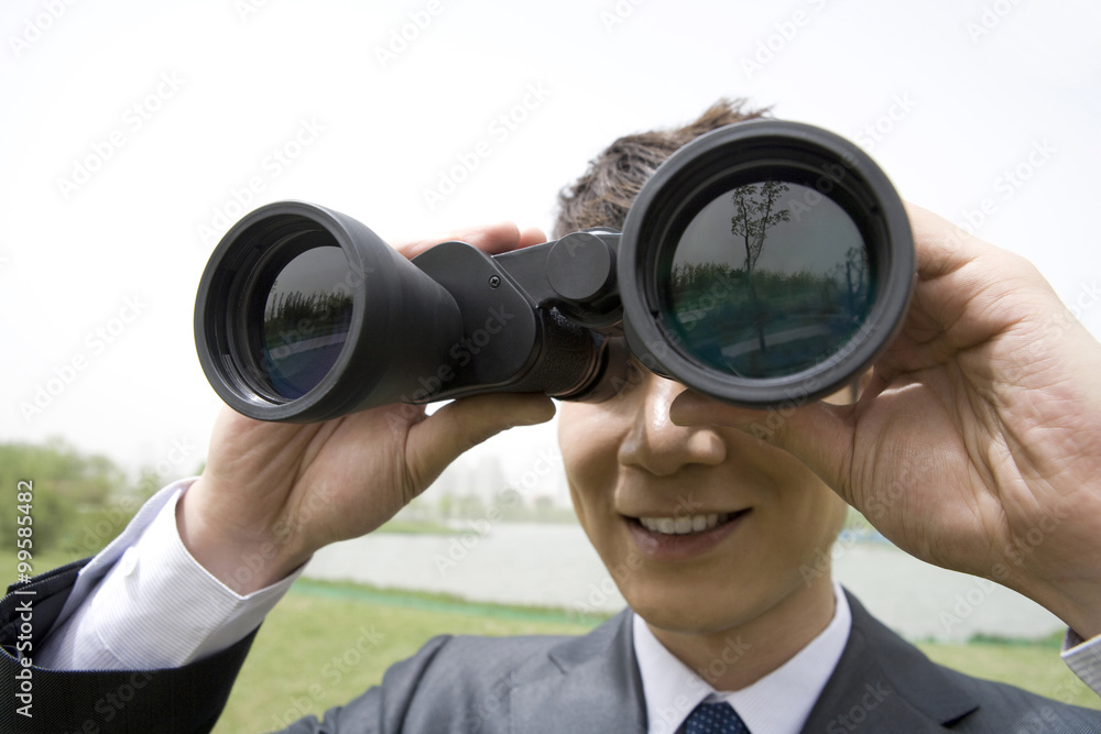 Businessman using binoculars