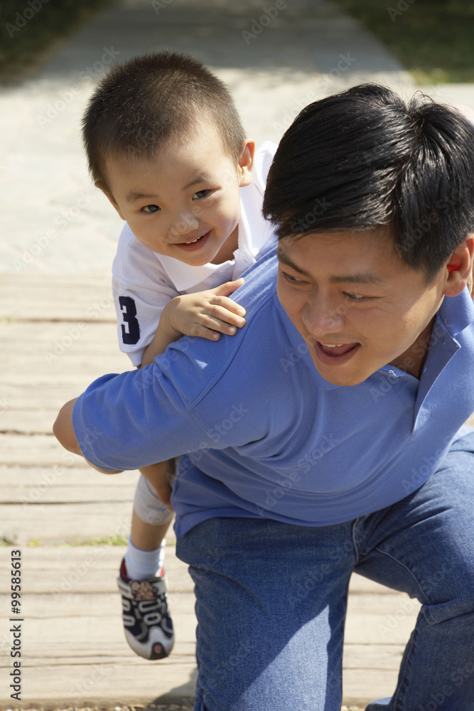 Father Giving Son A Piggyback Ride