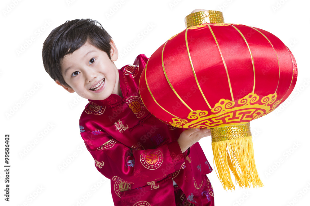 Happy boy in traditional clothing with red lantern in hands