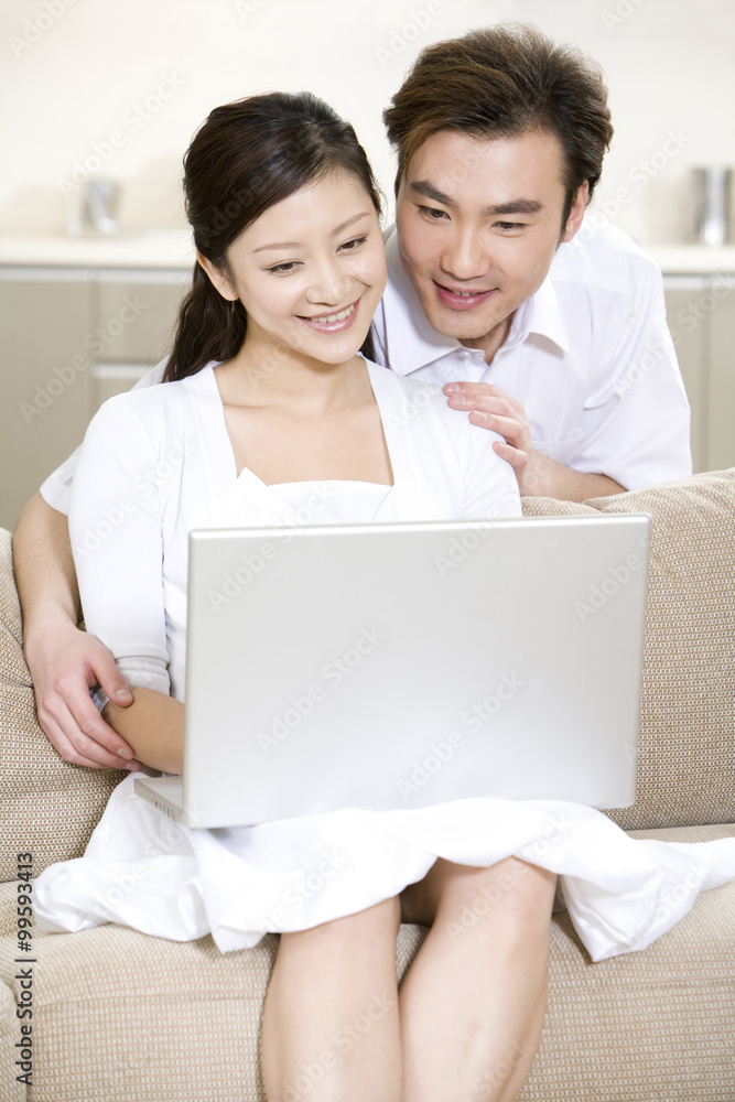 Young couple using a laptop at home