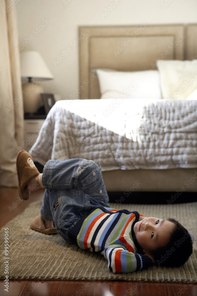 Boy Lying On Floor In Bedroom