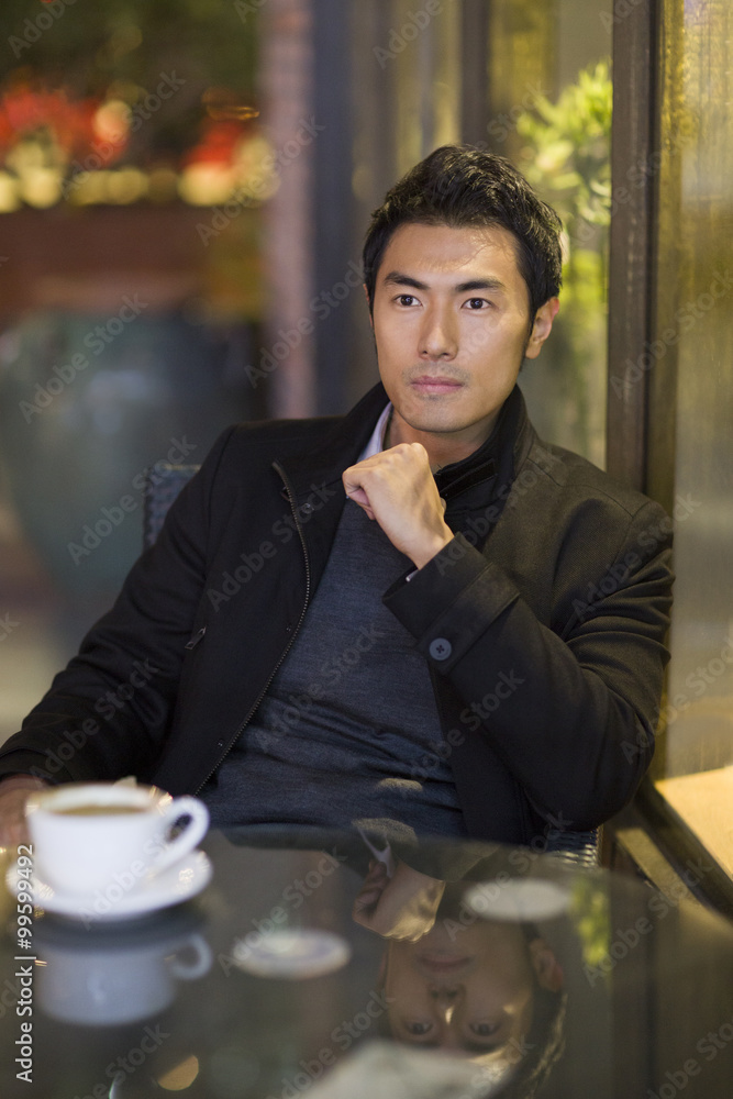 Young man drinking coffee in café