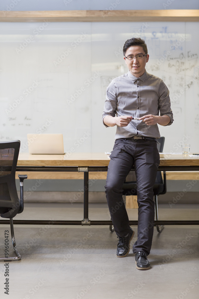 Young man standing in board room