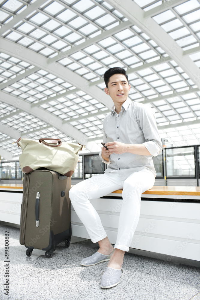 Young man with mobile phone at subway station