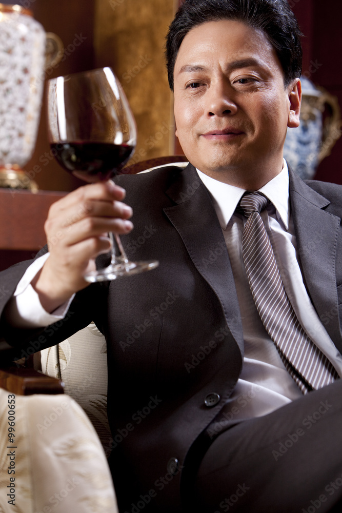 Mature businessman enjoying wine in a luxurious room