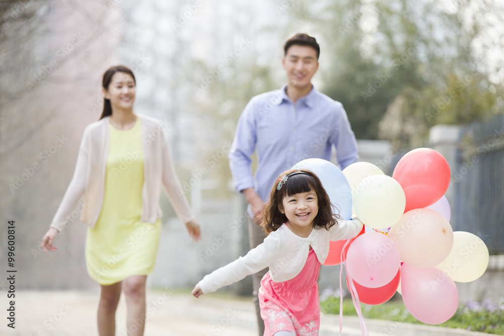 Happy young family running with balloons