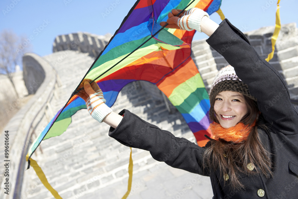 中国长城上的年轻女子放风筝