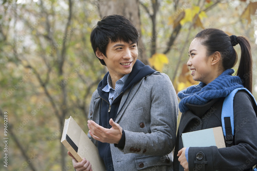 A young man and woman talking together on campus