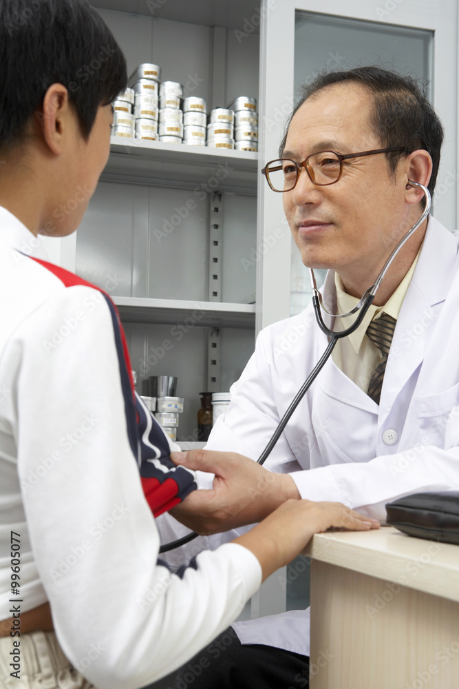 Doctor Listening To Patients Heart With Stethoscope