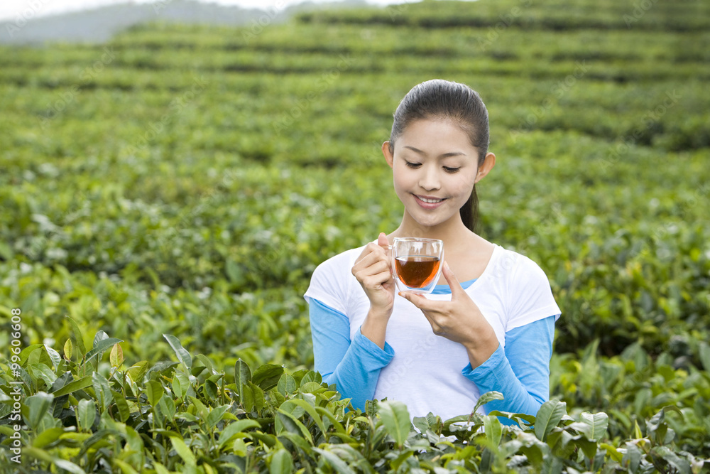 年轻女子在茶园喝茶