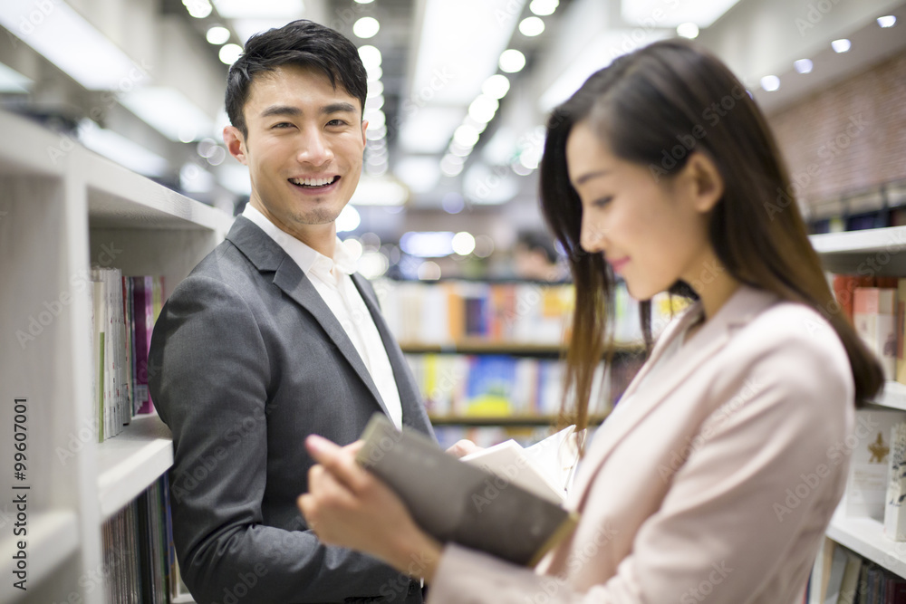 Young couple choosing books in bookstore