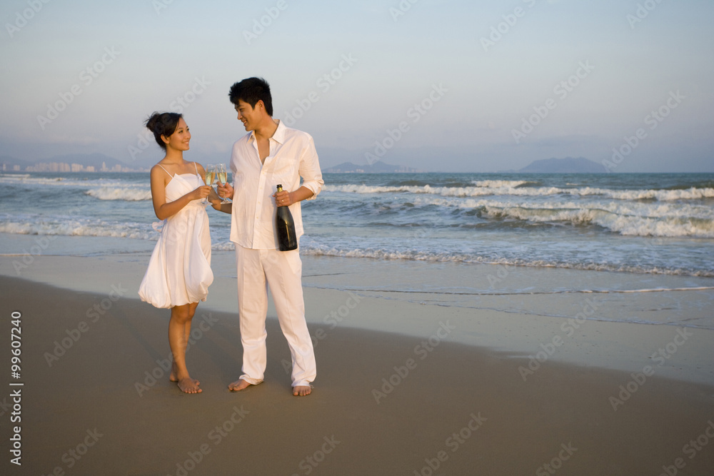 Young couple celebrating with a bottle of champagne