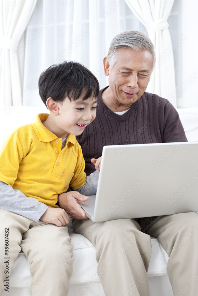 Grandpa and grandson using laptop