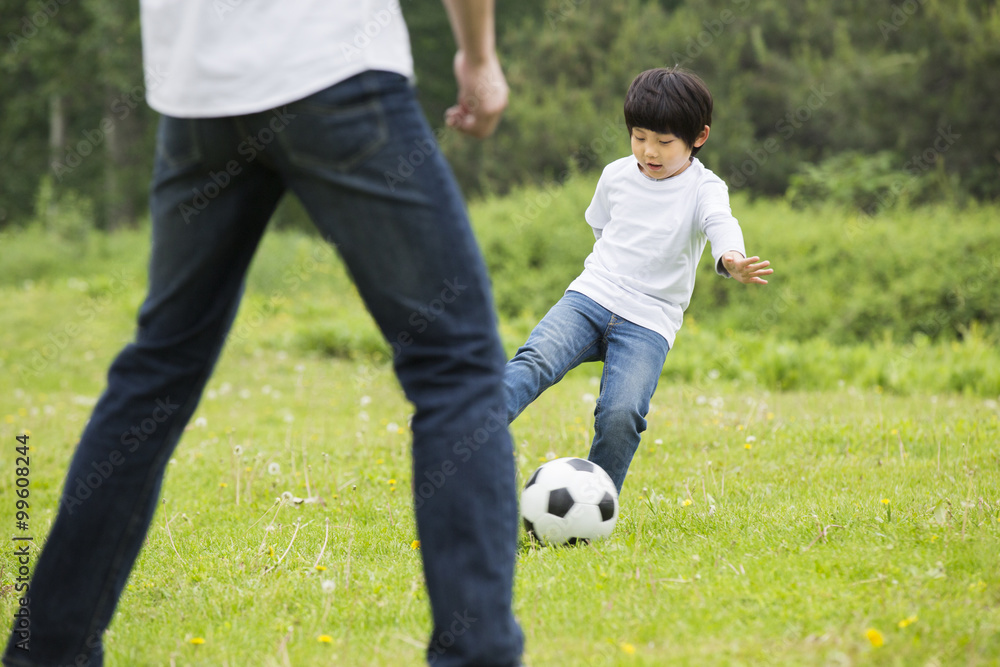 Happy father and son playing football together