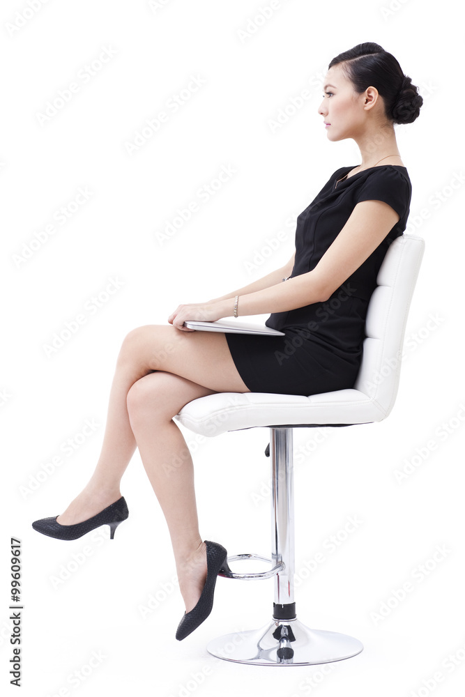 Cool businesswoman sitting on the chair with laptop in hand